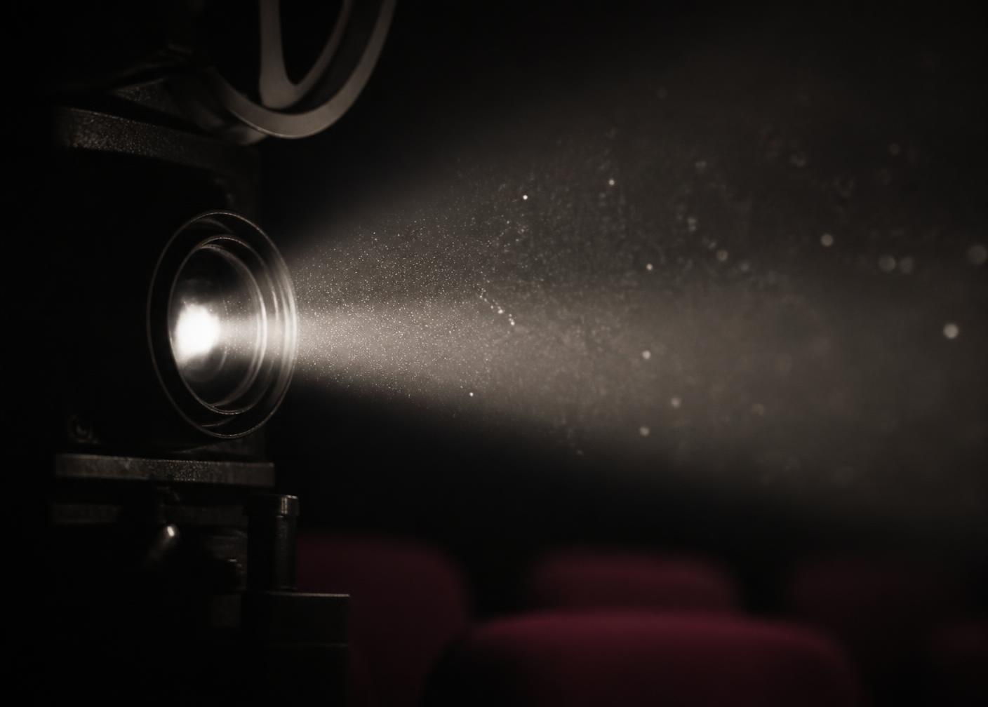 Lichtkegel eines Kinoprojektors im dunklen Saal